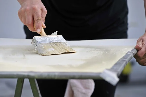 Person streicht Fläche mit Pinsel